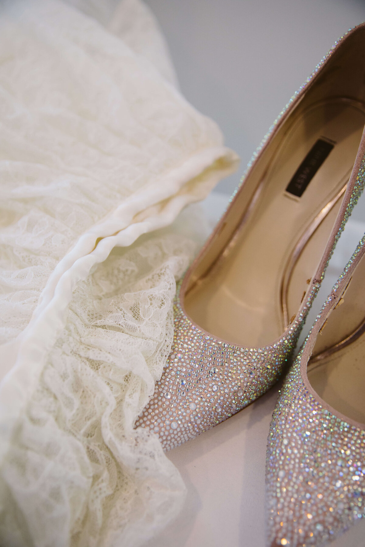 Details of rhinestone wedding heels and a lace dress