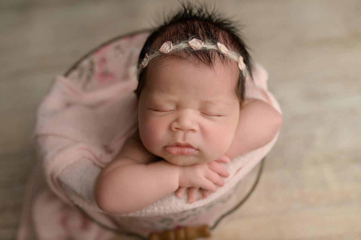 Close up of newborn baby posed in a bucket