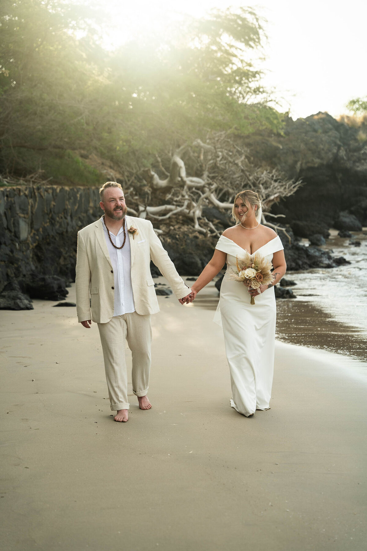 Couple walking across beach, taken by big island wedding photographers