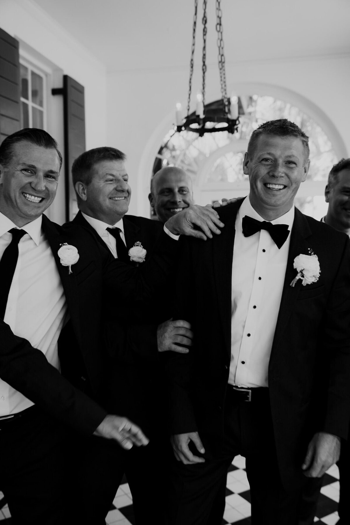Groom & groomsmen having fun before wedding captured by Charleston wedding photographers