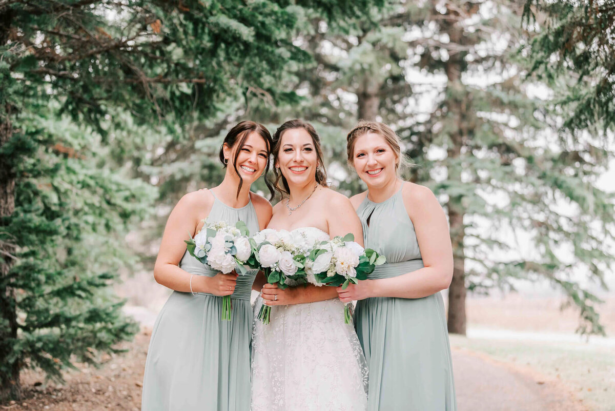 Bride and the bridesmaids stand close together. 