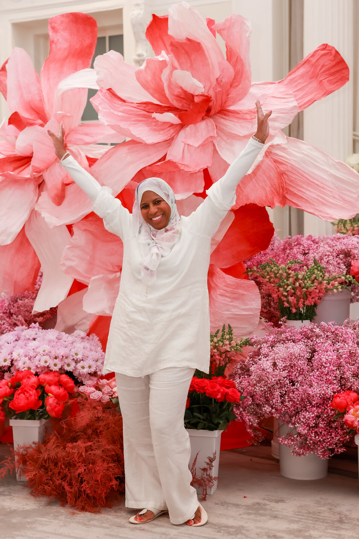 owner, planner, designer smiling against a backdrop of fresh, vibrant florals, showcasing a passion for event design and floral artistry, designed by In Full Bloom Event Planning & Design