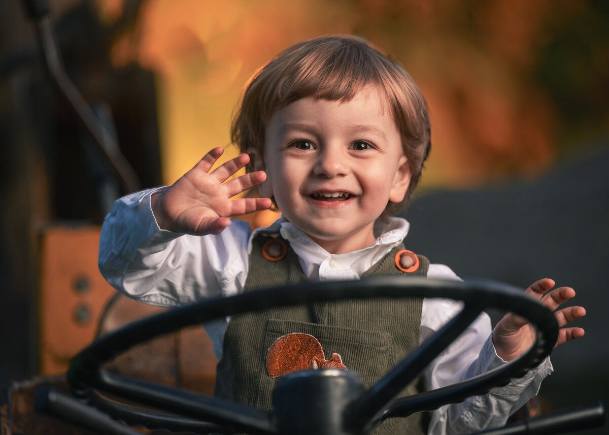 Family enjoying a photography session on a farm near Boston,  toddler on a tractor