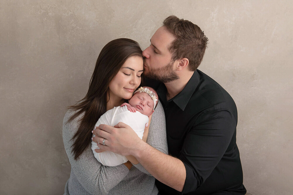 Mom and dad holding their baby girl.