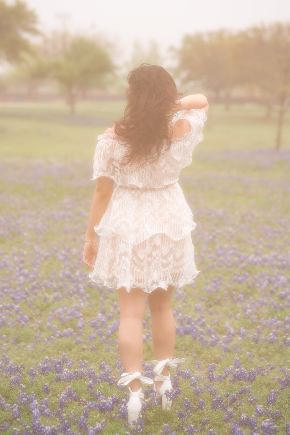 High school senior girl posing in flowers for graduation photos. Austin Senior Graduation.