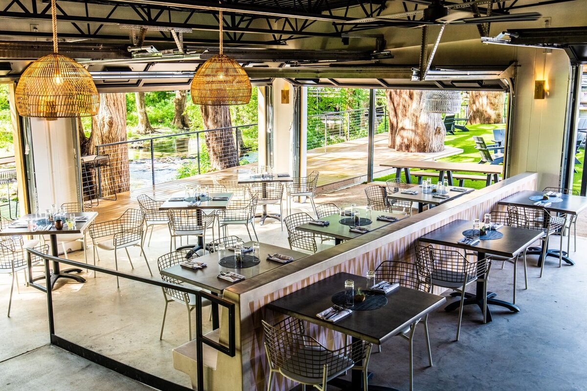 Creekhouse restaurant with multiple tables and hanging wooden lights