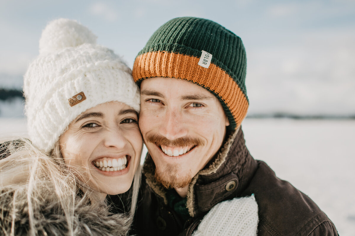 jackson hole photographers photographs close up of engaged couple smiling during their winter engagement session in the Grand Tetons