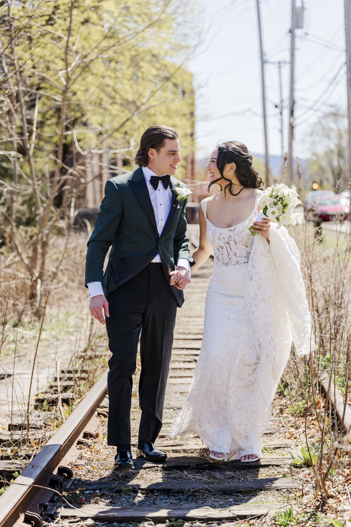 Bride and groom walk down the train tracks in Beacon NY by The Roundhouse wedding venue