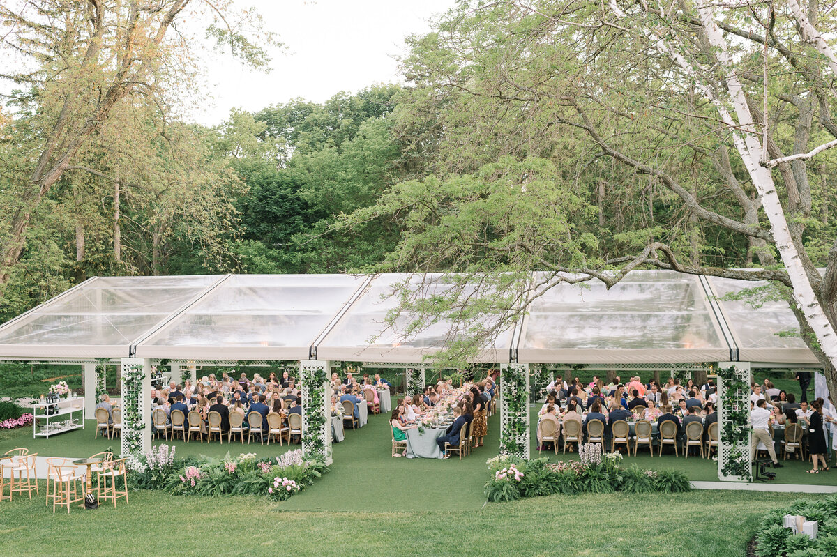 Wide image of a large tented backyard wedding