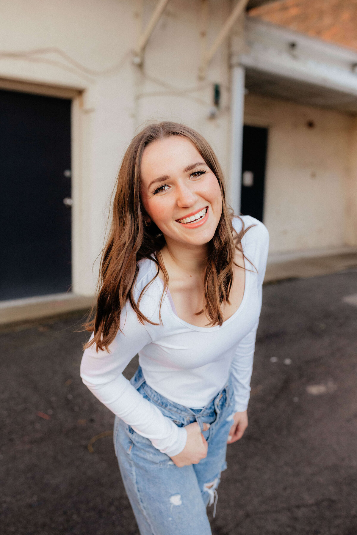High school senior posing in jeans and white top, Ohio senior photography for confident grads who want modern, fun photos with personality