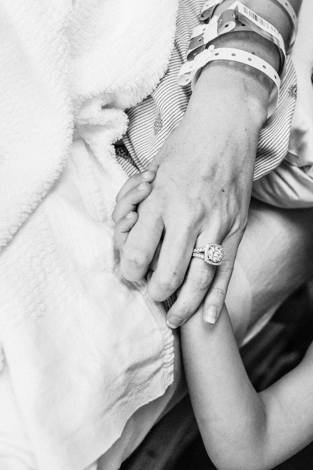 Husband and wife holding hands during birth of baby