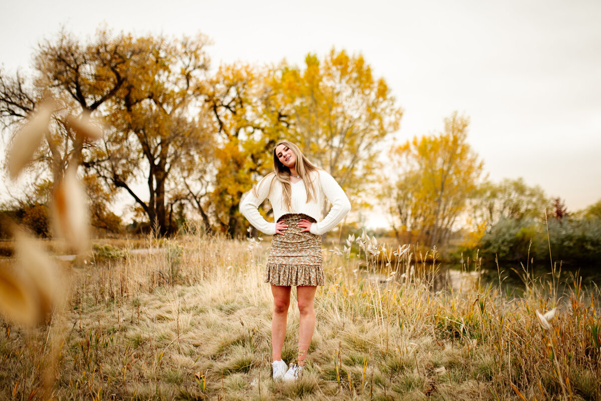 cool boho chic senior pictured among field and large oak trees