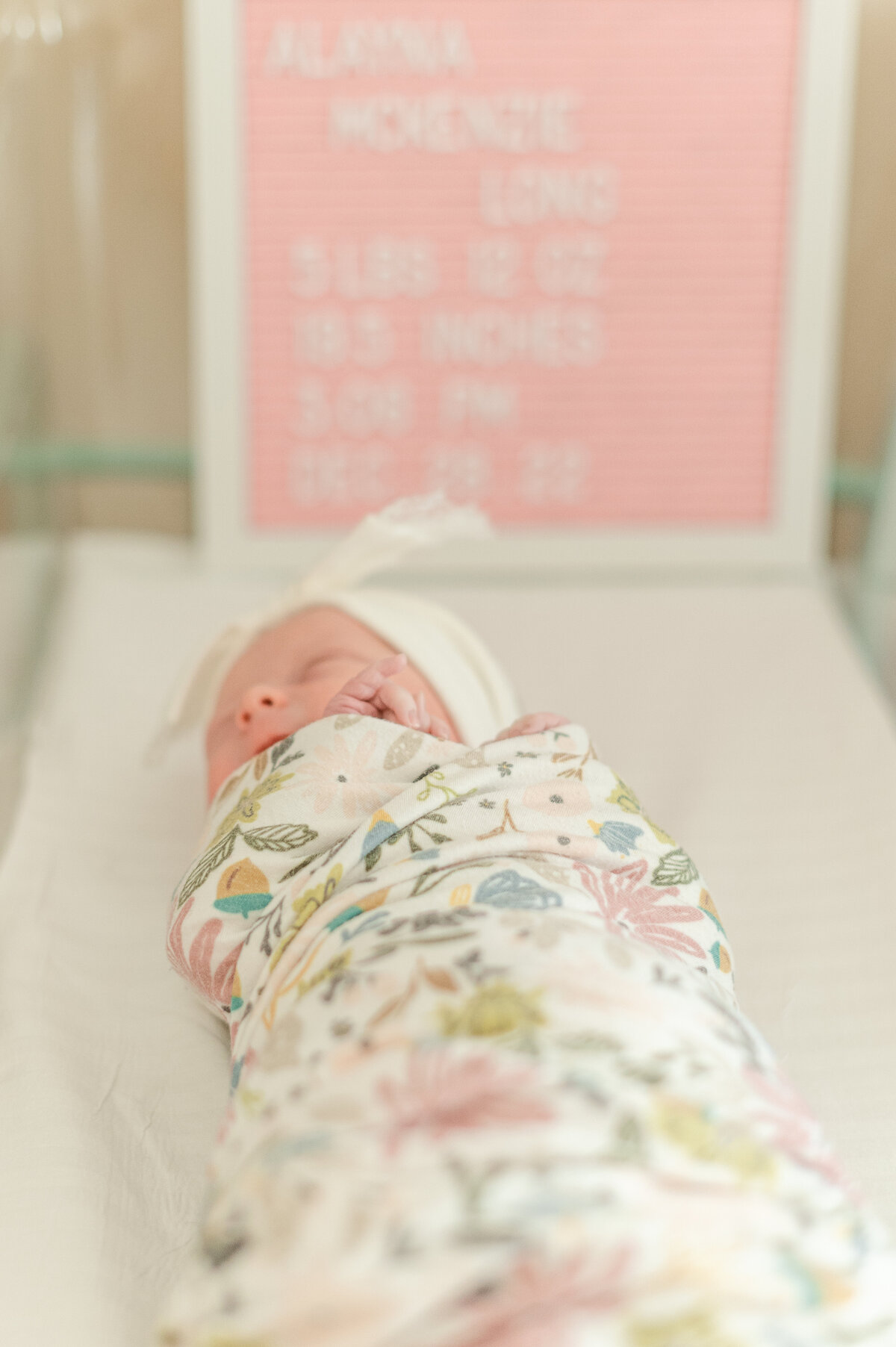 newborn sleeping in bassinet wrapped in flower blanket at hospital harrisburg pa