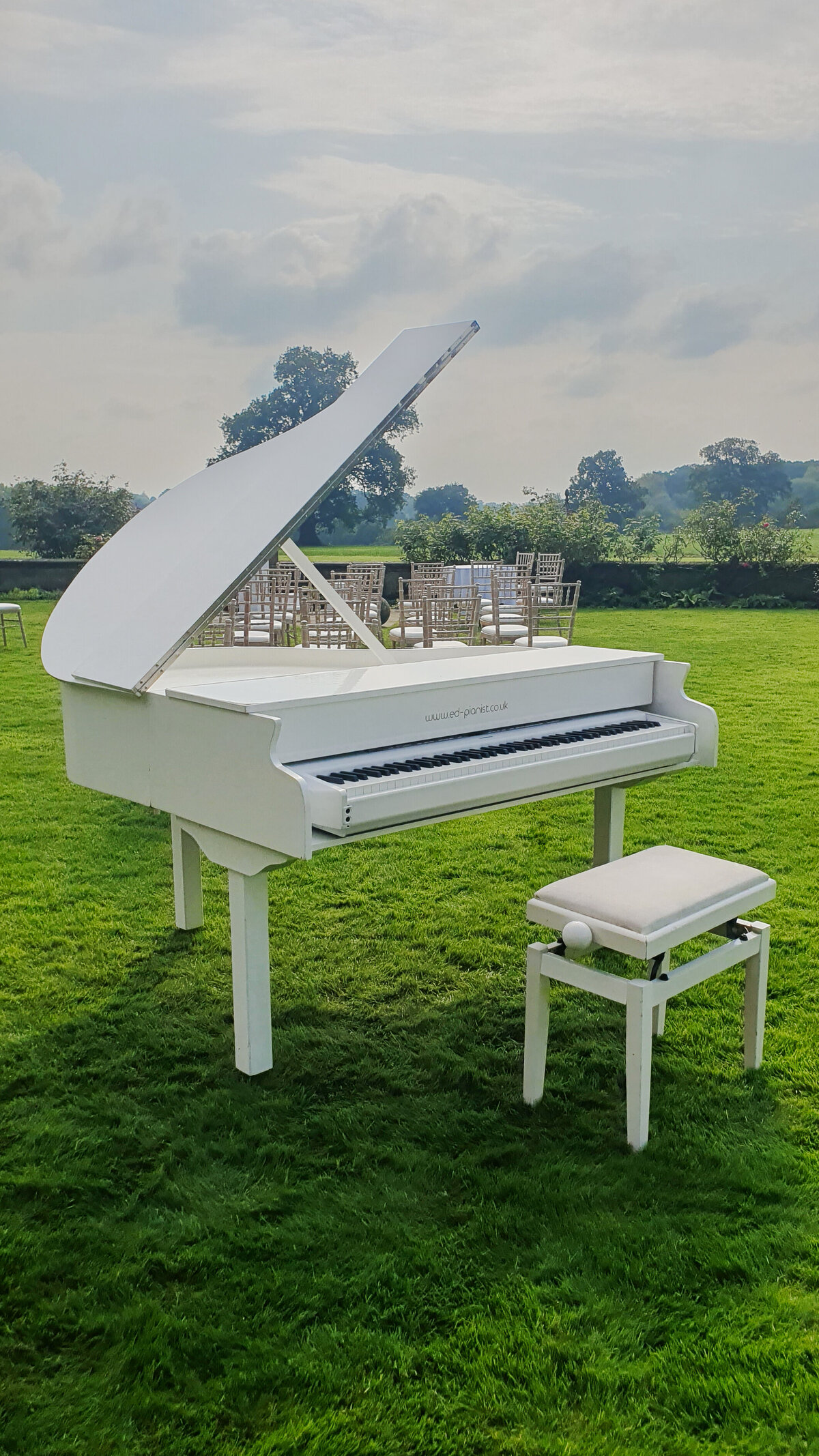 white baby grand piano on lawn outside