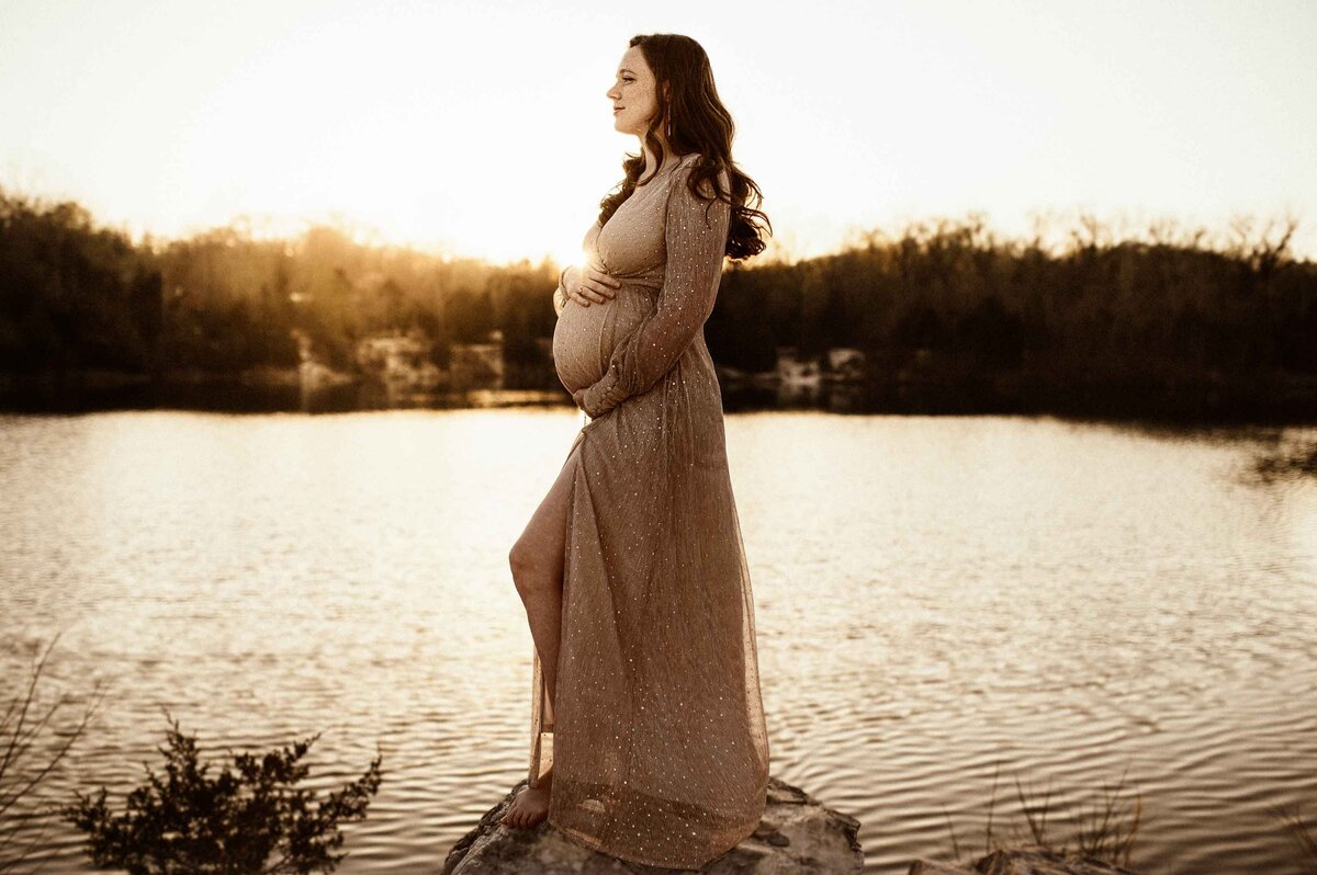 Expecting-mother-outdoor-maternity-session-at-Klondike-Park-standing-on-rock-by-water-in-Baltic-Born-Sparkle-dress