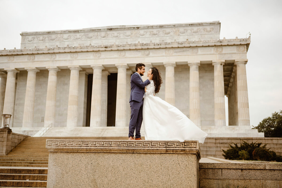 Bride and Groom stand on column in front of the Lincoln Memorial during their Washington DC elopement
