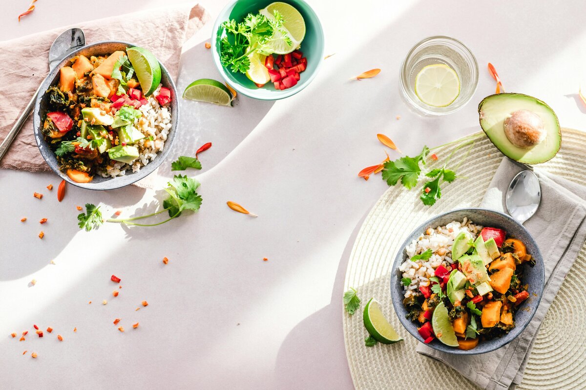 Fresh and colorful meal with rice, roasted vegetables, avocado, and lime — symbolizing a nourishing, HAES-aligned and somatic approach to nutrition counseling.