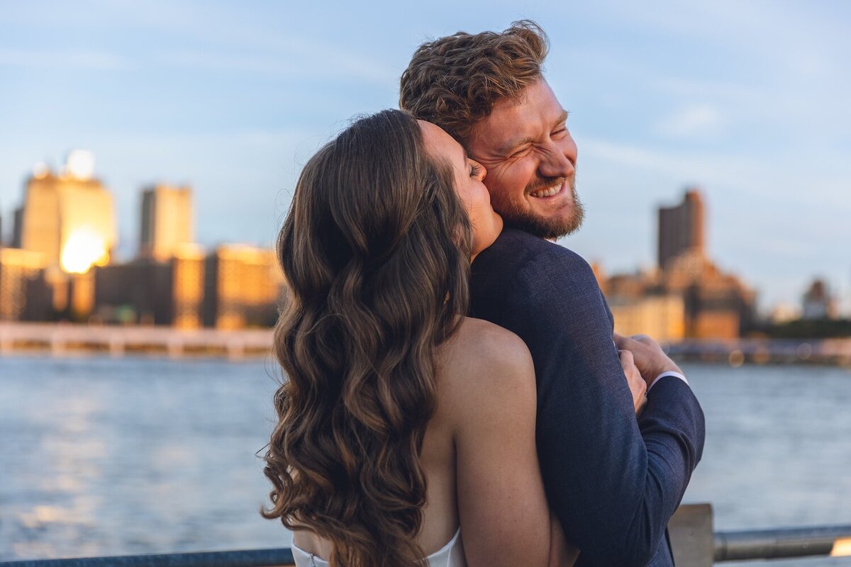 Bride and groom embracing against New York skyline backdrop