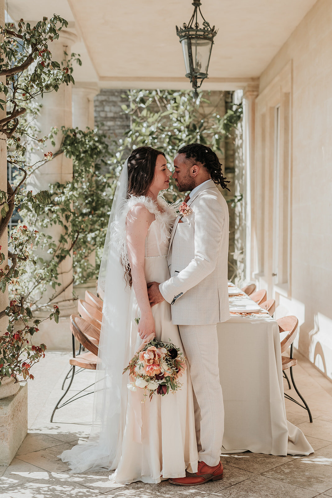 Bride and Groom kissing gently in front of their elegant cream table set up at their wedding at Euridge Manor