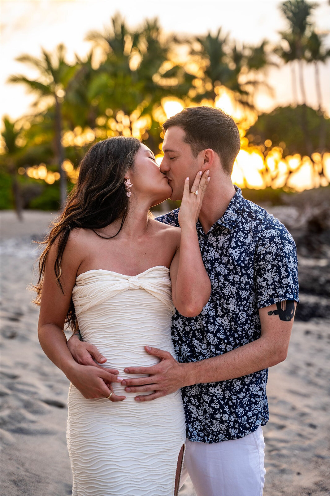 Couple kissing for Hawaii engagement photos during sunset
