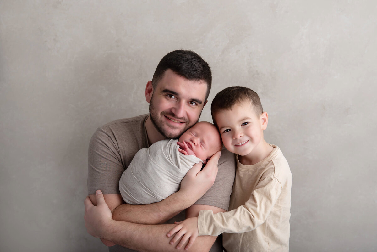 Dad with his older son and newborn baby boy for their newborn photography session in Burlington, Ontario