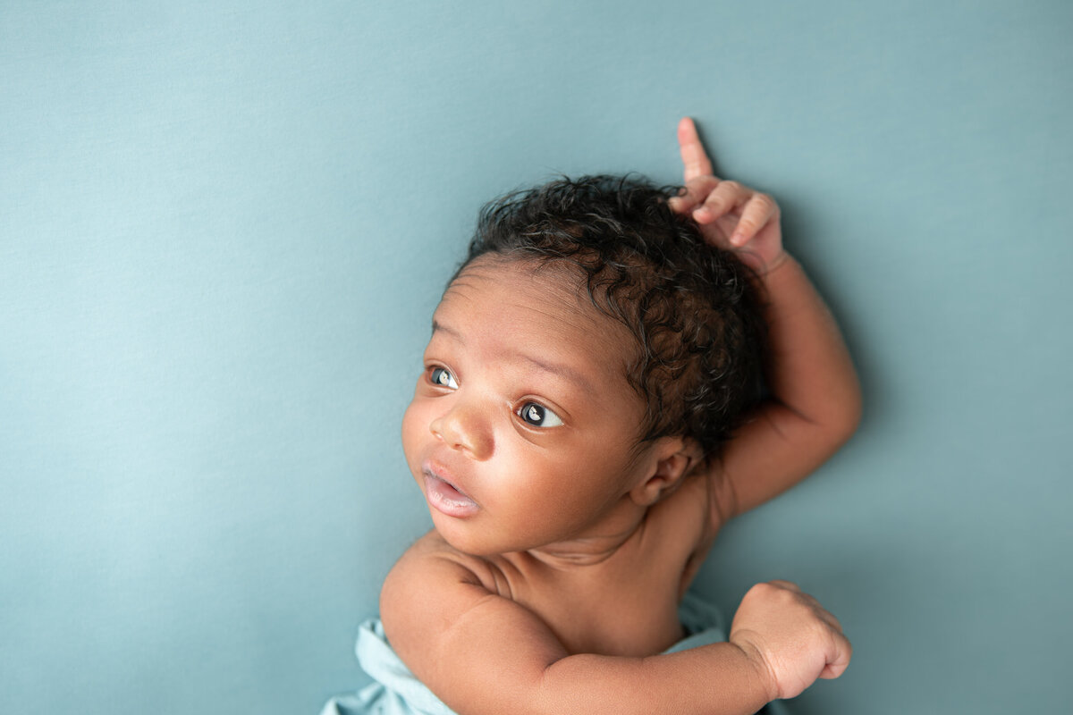 Newborn table pose on a blue backdrop