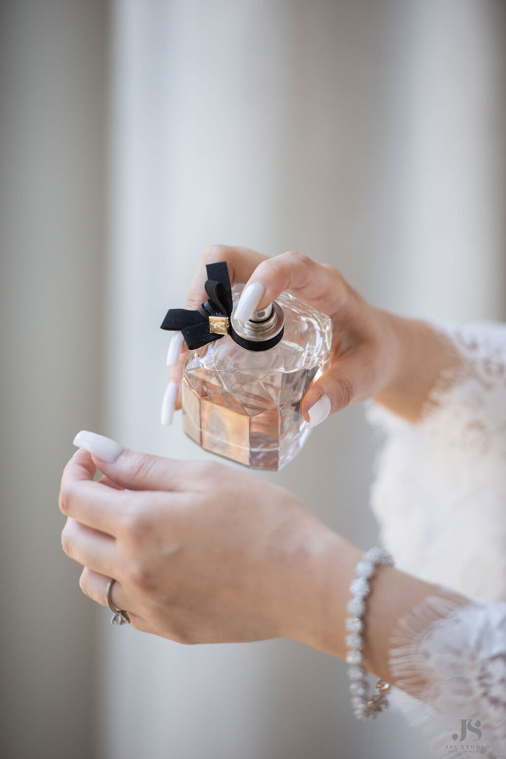 Bride puts on perfume on her wedding day at the Halcyon Hotel in Cherry Creek, Colorado.