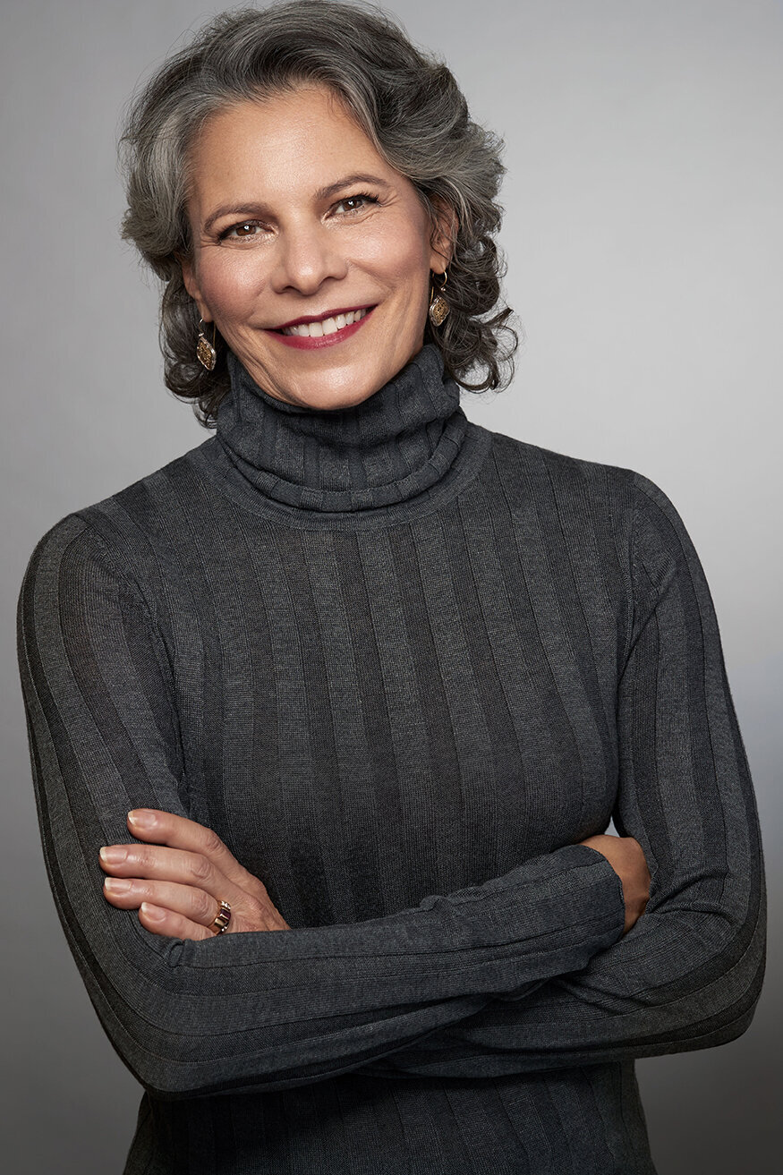 Confident portrait of Cynthia in a grey sweater, exuding warmth and professionalism, captured by Ylva Erevall.