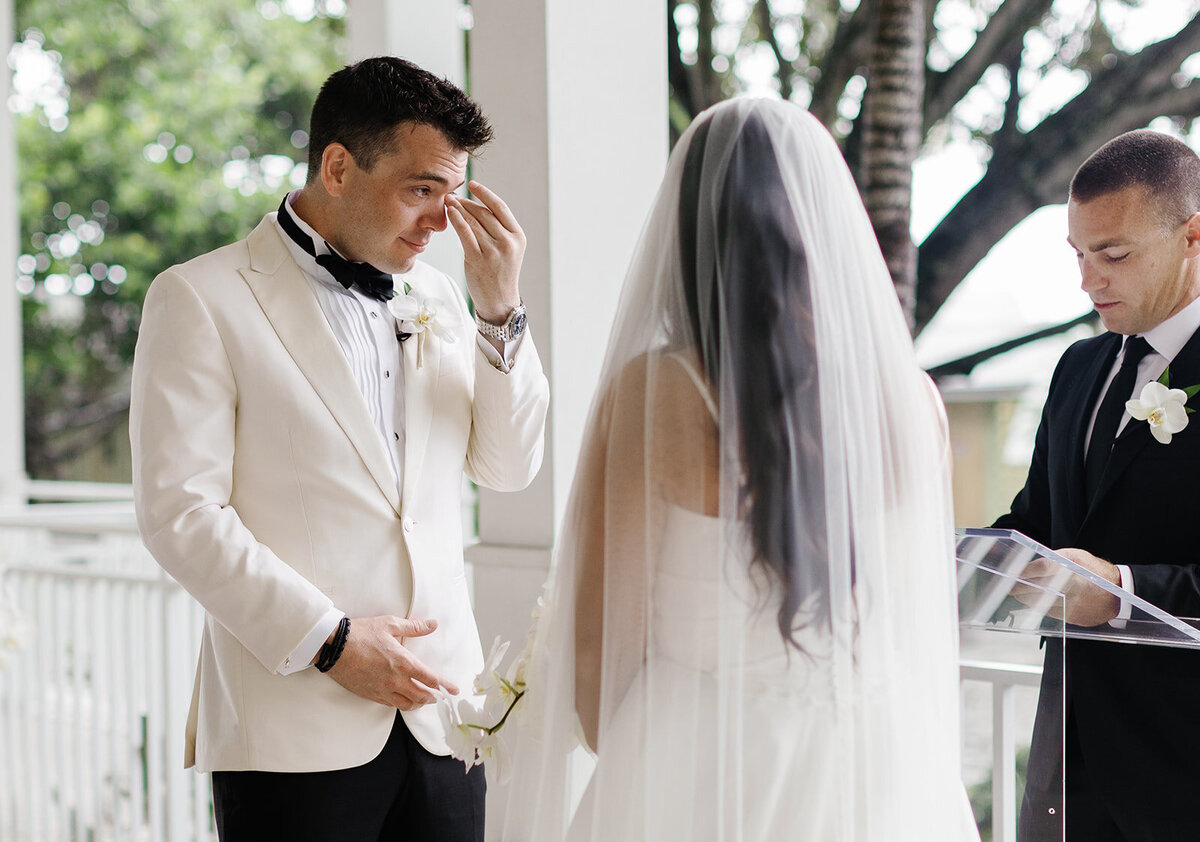 The groom emotionally expressing his love during the vow exchange at Ocean Reef in Key Largo, captured by Claudia Amalia Photography.