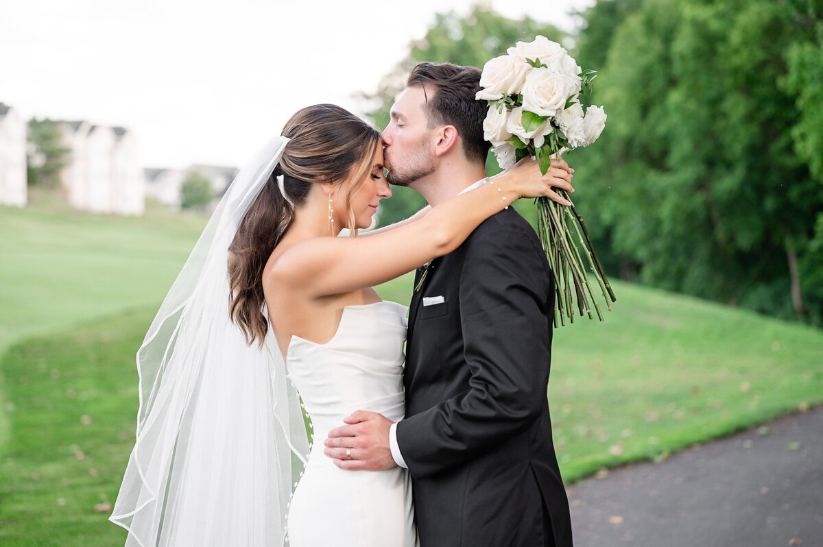 groom kissing brides forehead