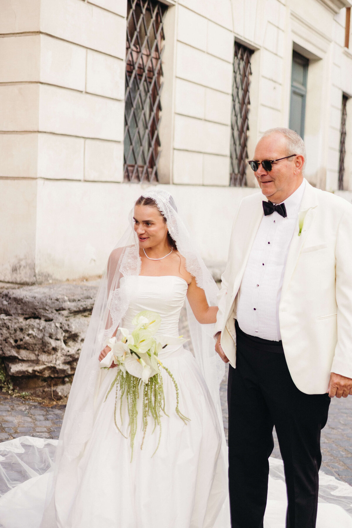 Bride and her father smiling together before entering the church

