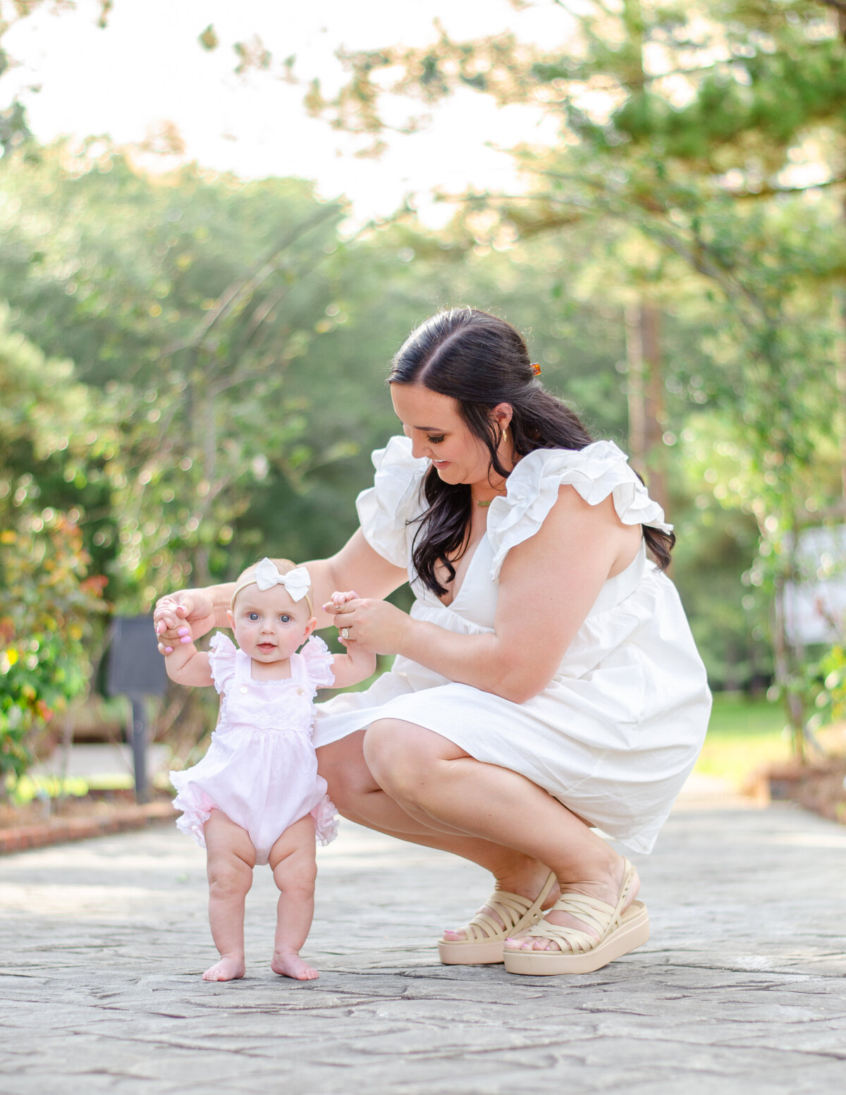 a mom helps her six month old walk