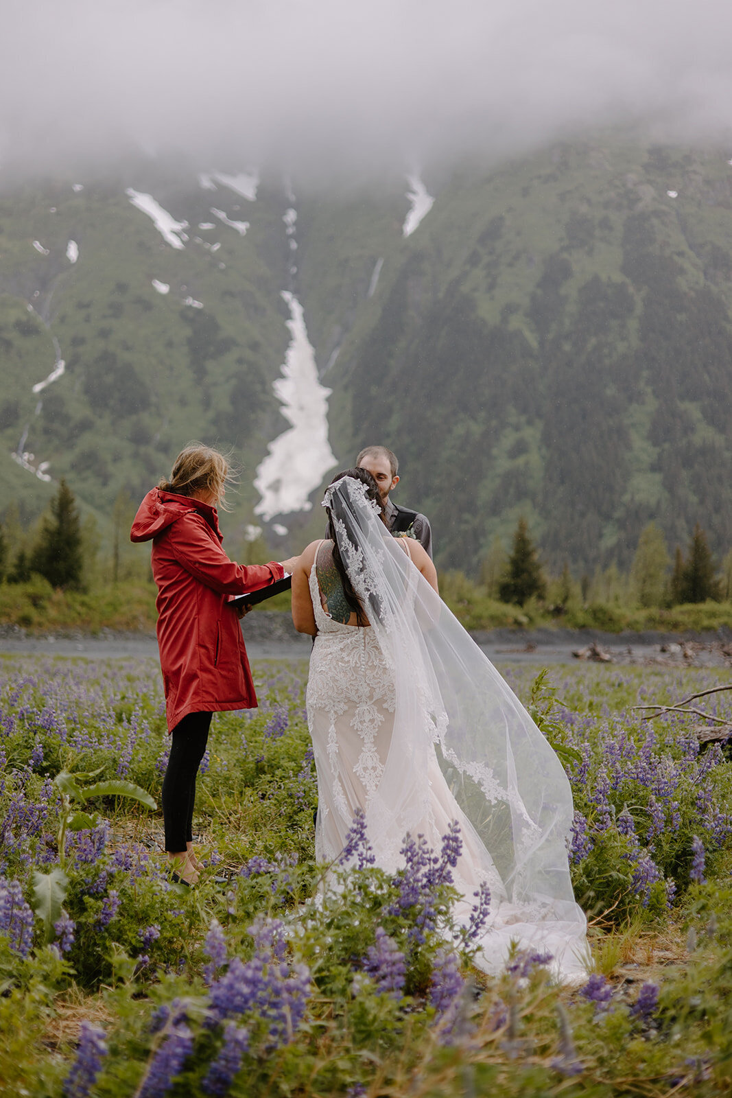 Elopement couple recites vows in flower field with mountain view