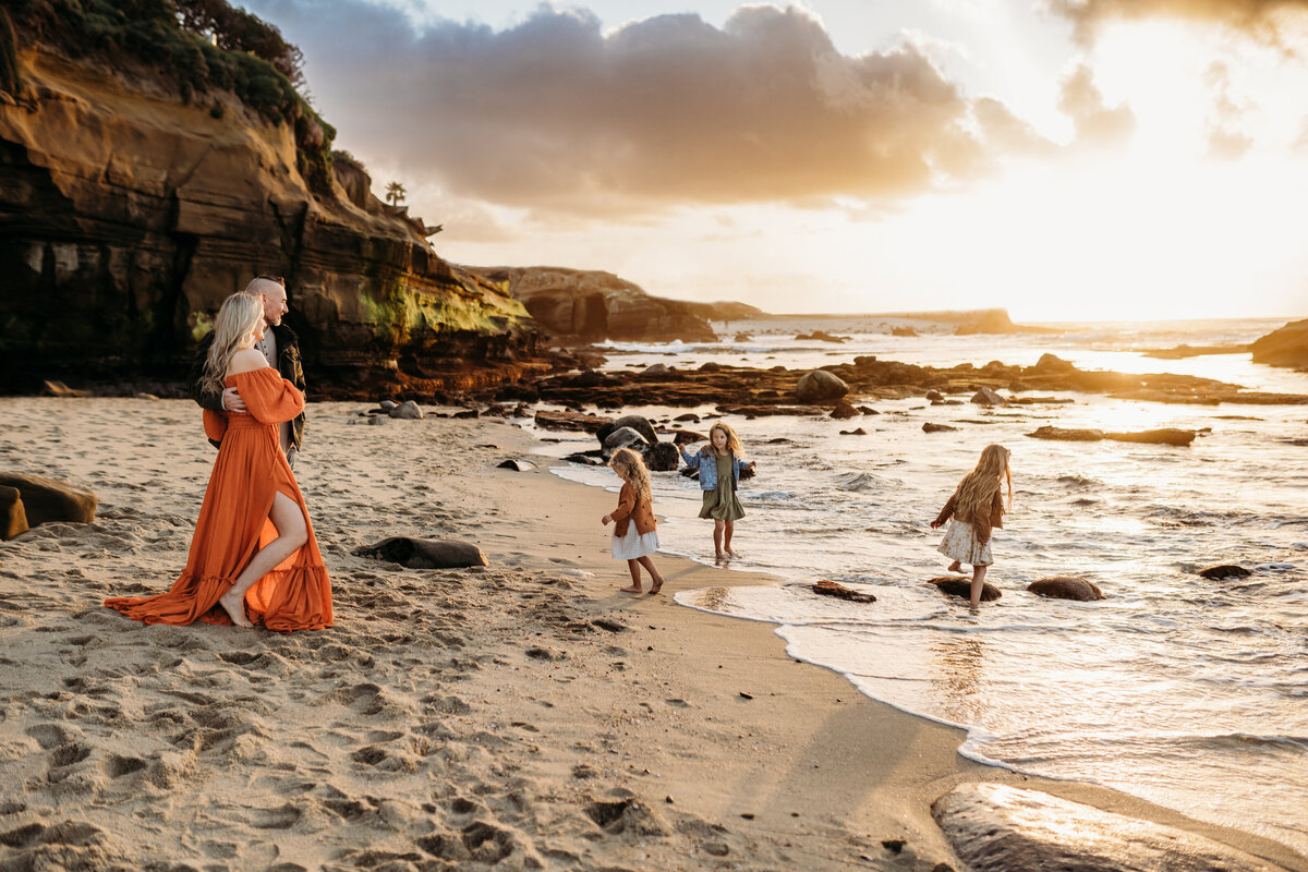 Family of five playing at the beach in La Jolla, California.