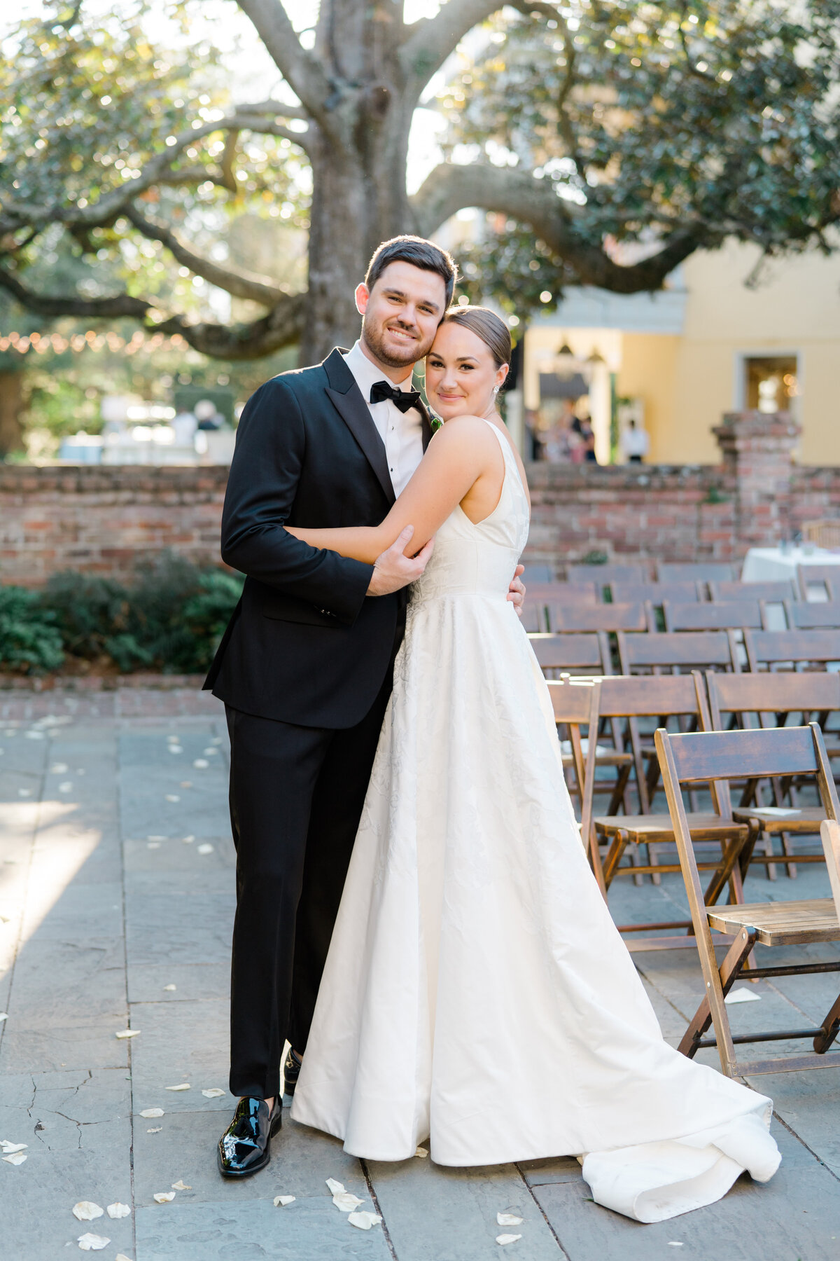 Bride and groom portrait in perfect sunset light during cocktail hour at William Aiken House. East Coast Destination Wedding photographer.  Old magnolia tree in the garden.