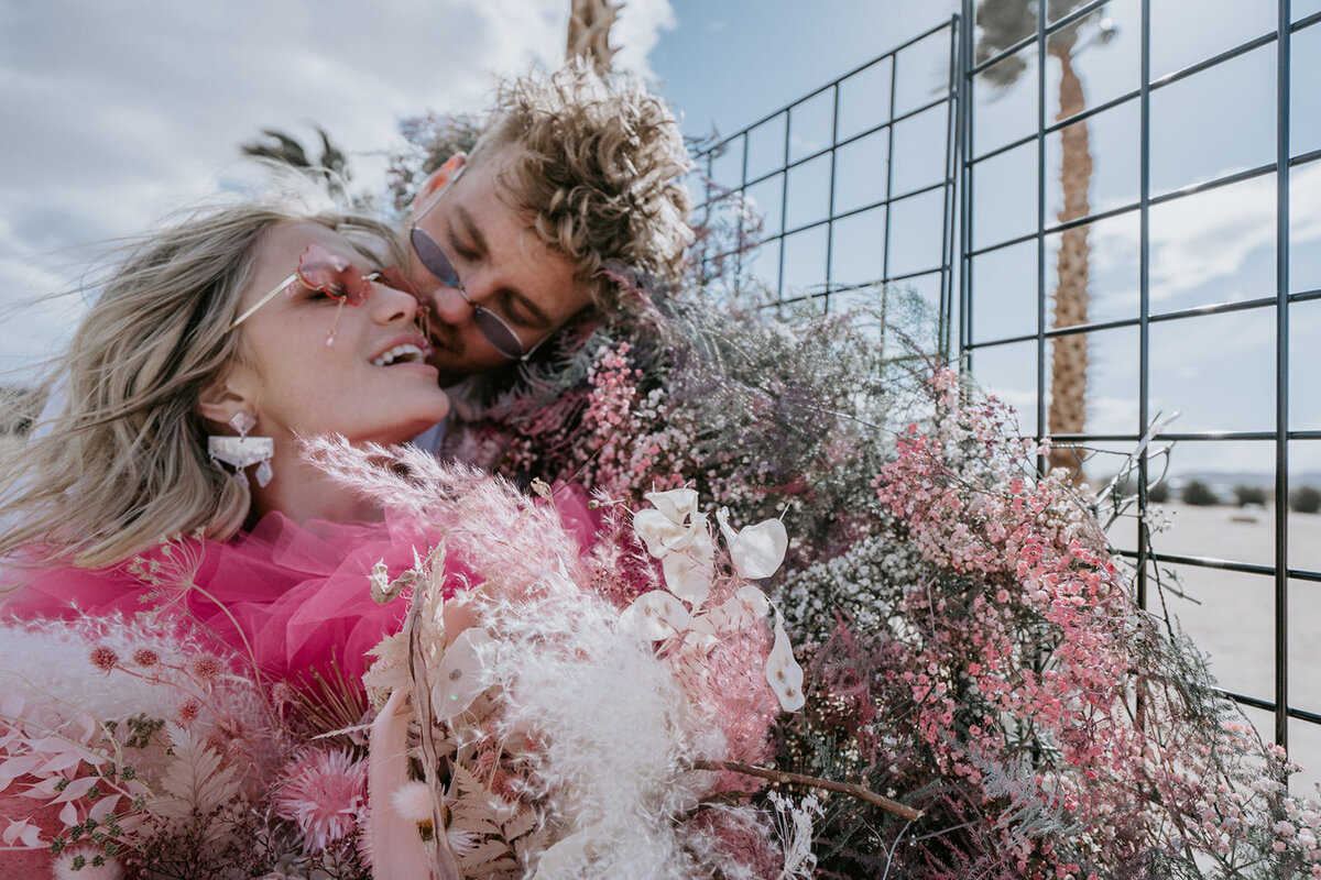 Couple eloping in Joshua Tree with beautiful pink pops of color.