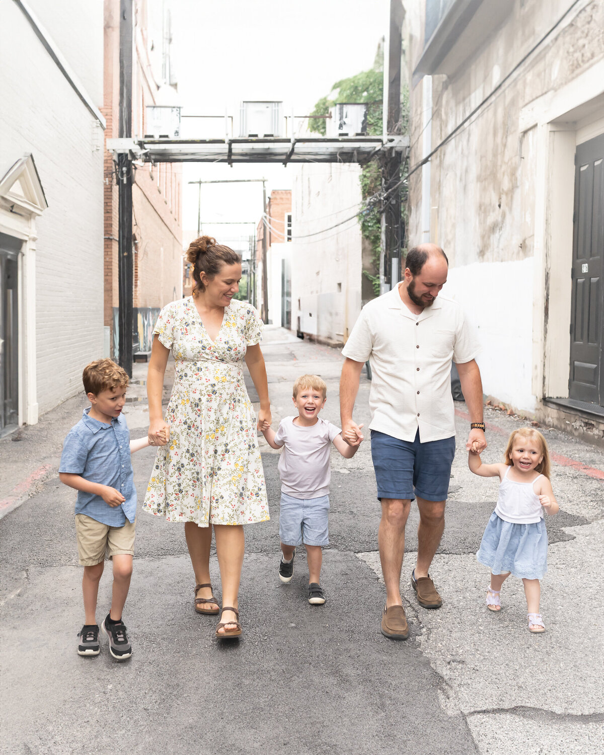 family with small kids walking downtown in an industrial area