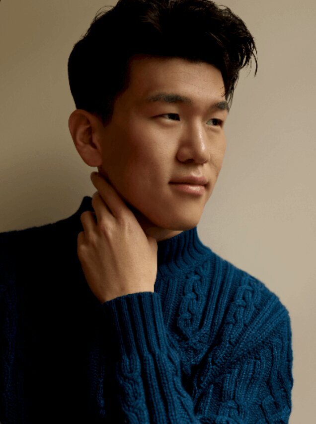 studio business portrait of a man looking to the side wearing a blue sweater