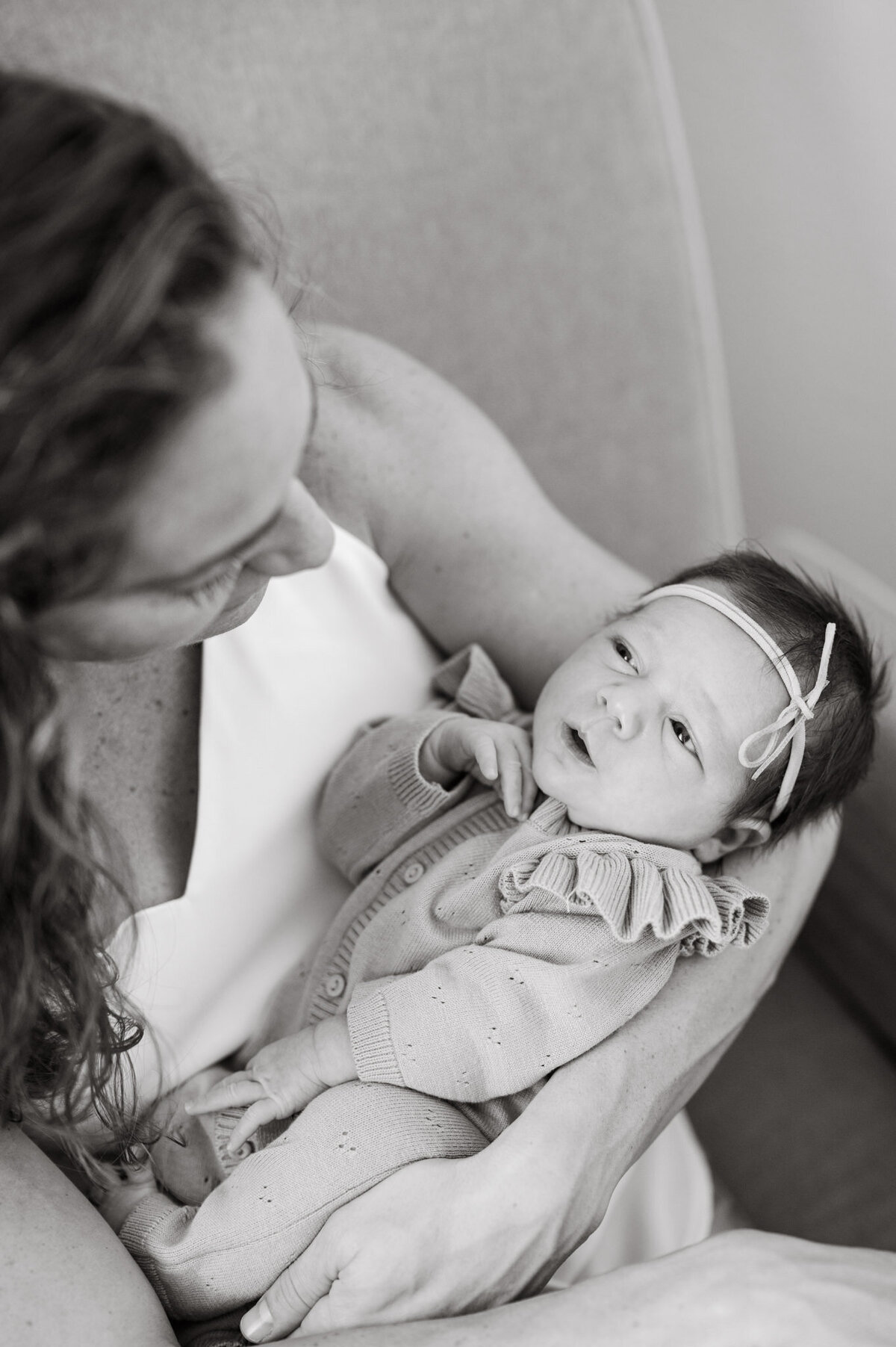 Baby girl gazes up at mom during San Antonio lifestyle newborn photos with Cassey Golden.