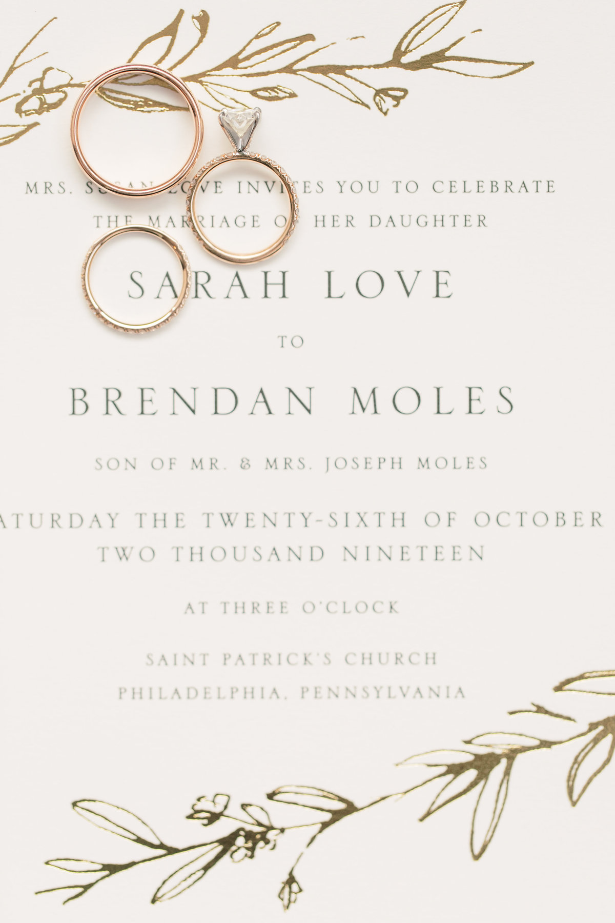 cream wedding invitation with greenery and wedding rings