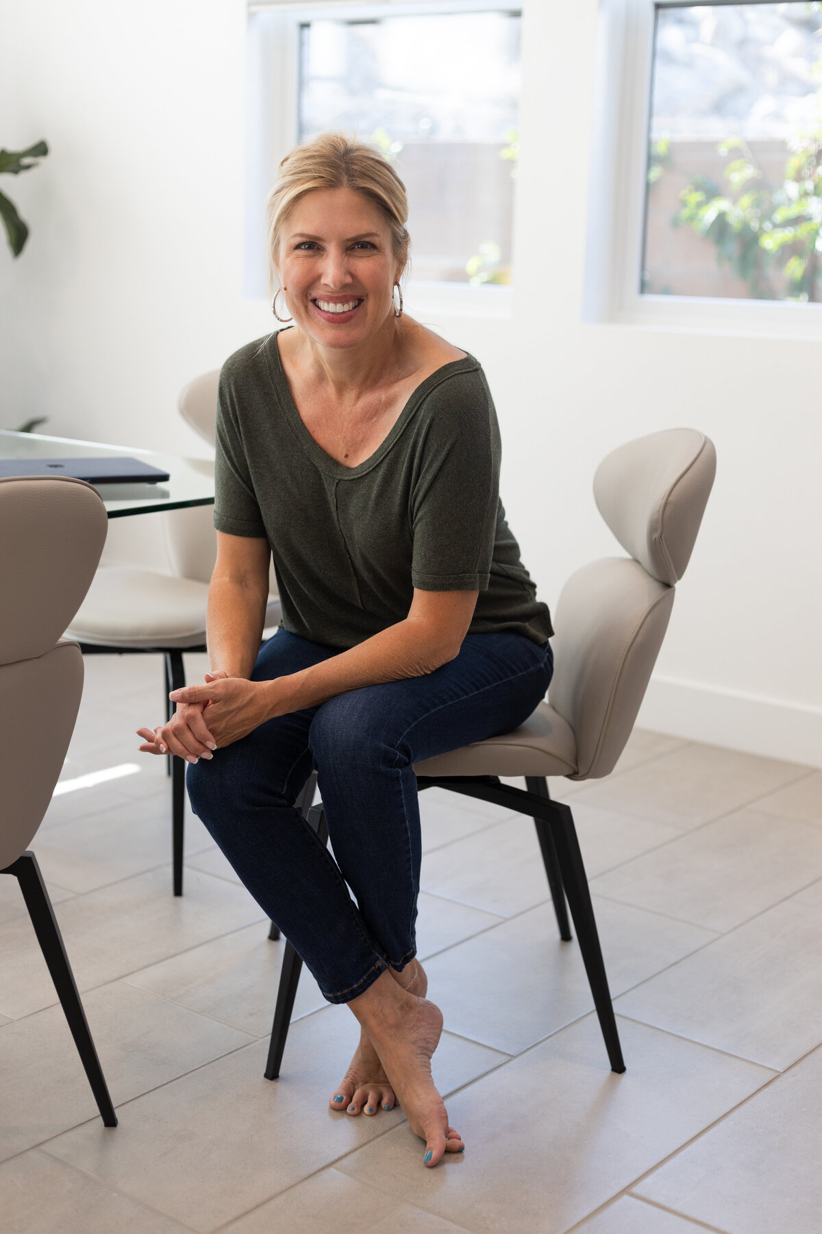 Accountant at her dining room table. She is smiling at camera.