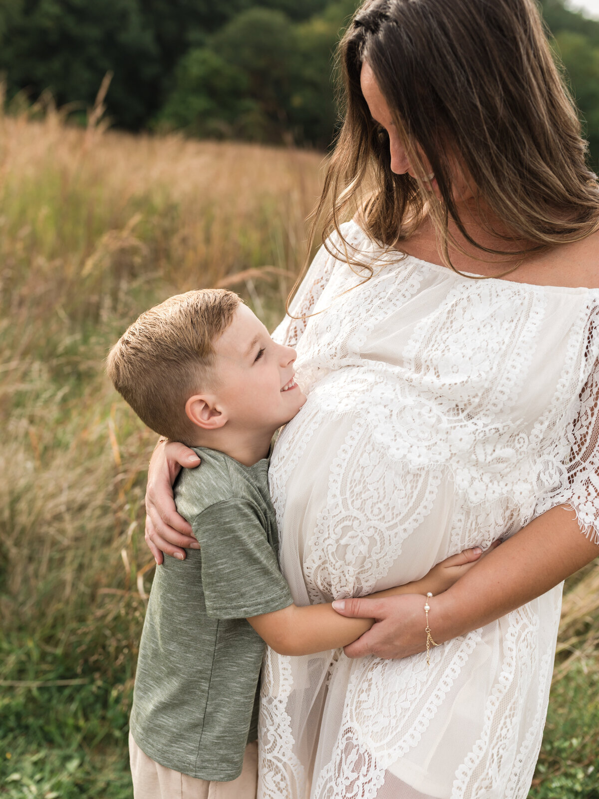 son hugging pregnant mother's belly for maternity photoshoot