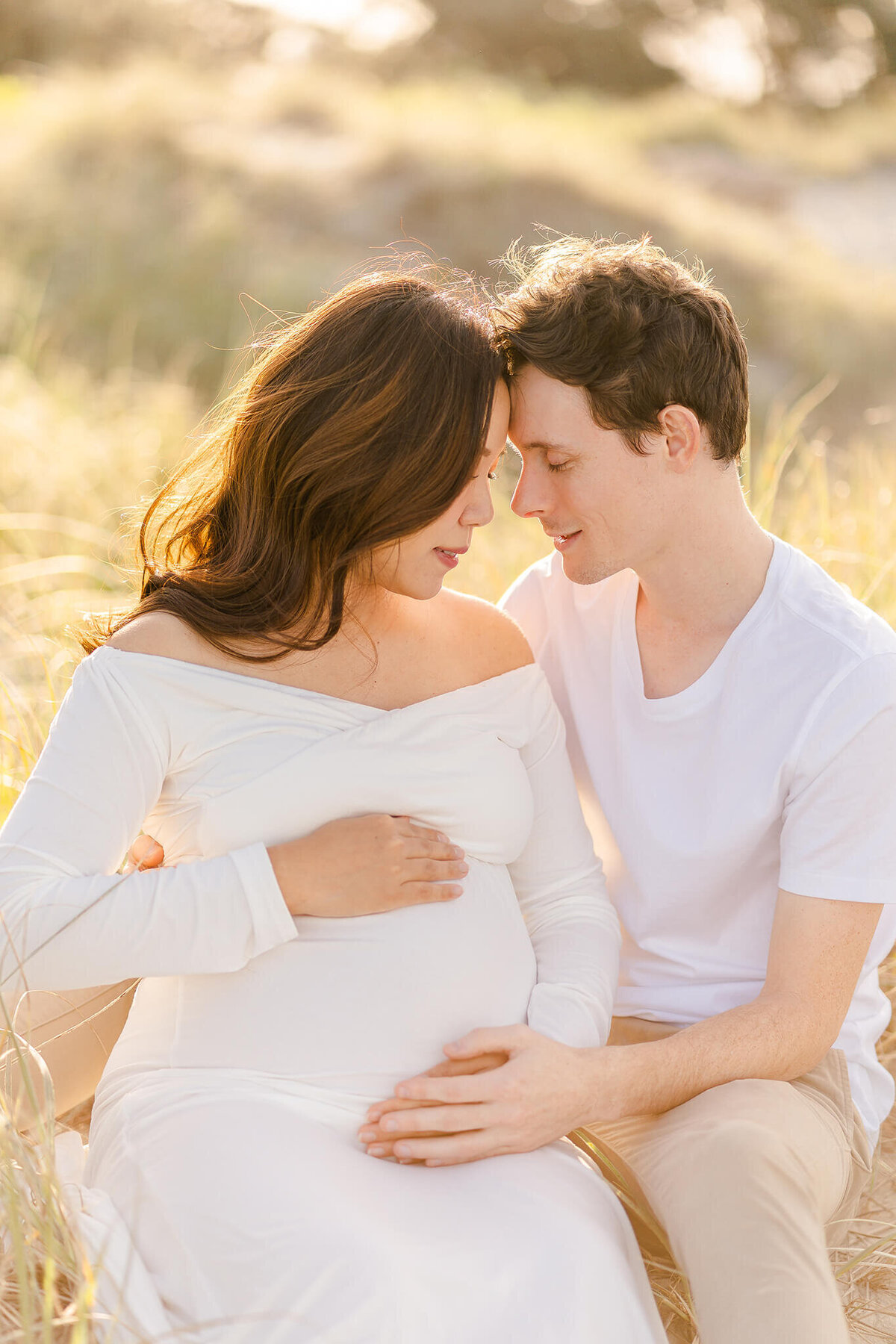 Couples forehead touching for maternity photoshoot during sunset in Gold Coast QLD