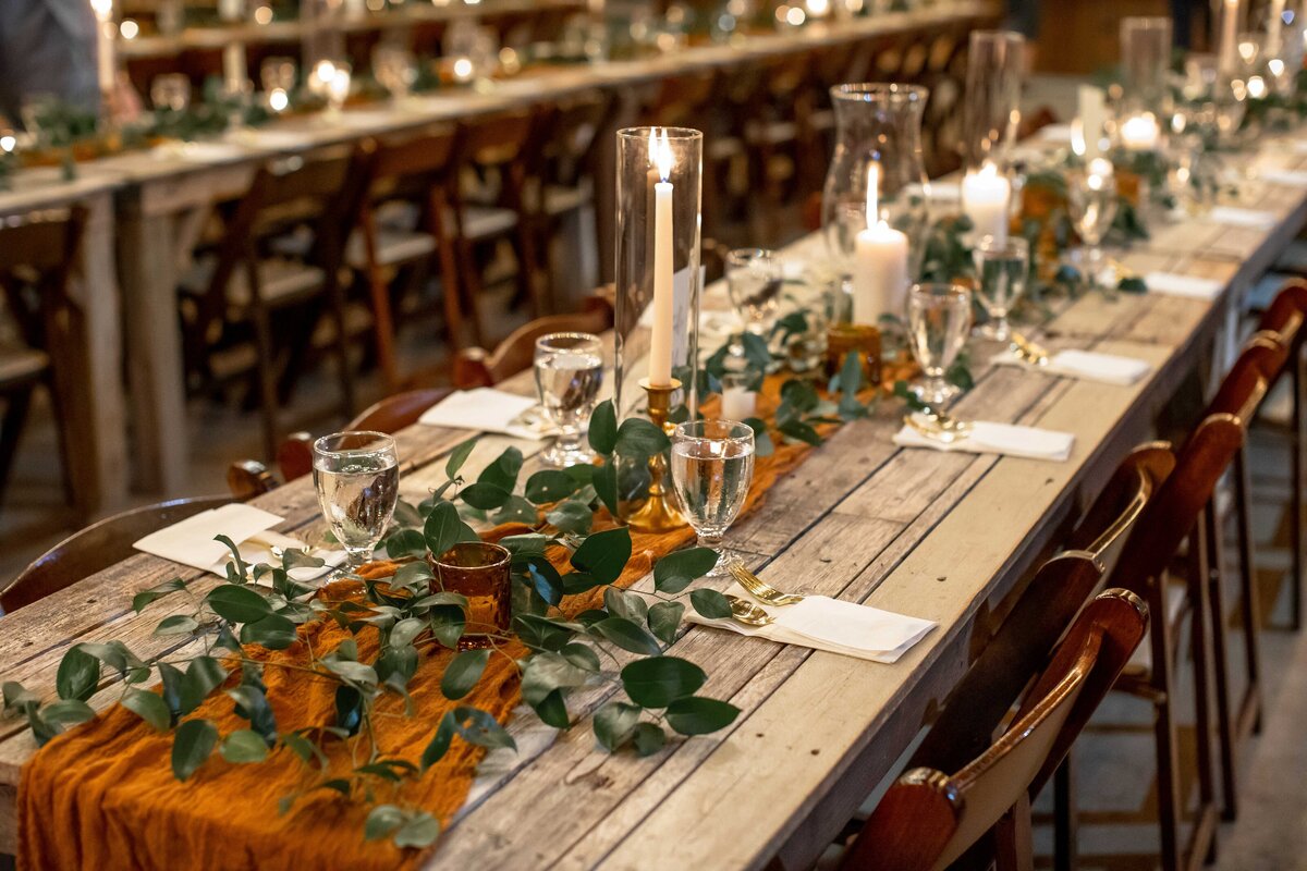 long tables decorated with burnt orange cloth candles and greenery Allen Farmhaus wedding New Braunfels Texas