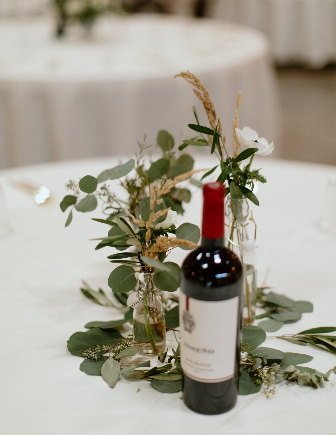 Foliage and bud vases with white flowers.