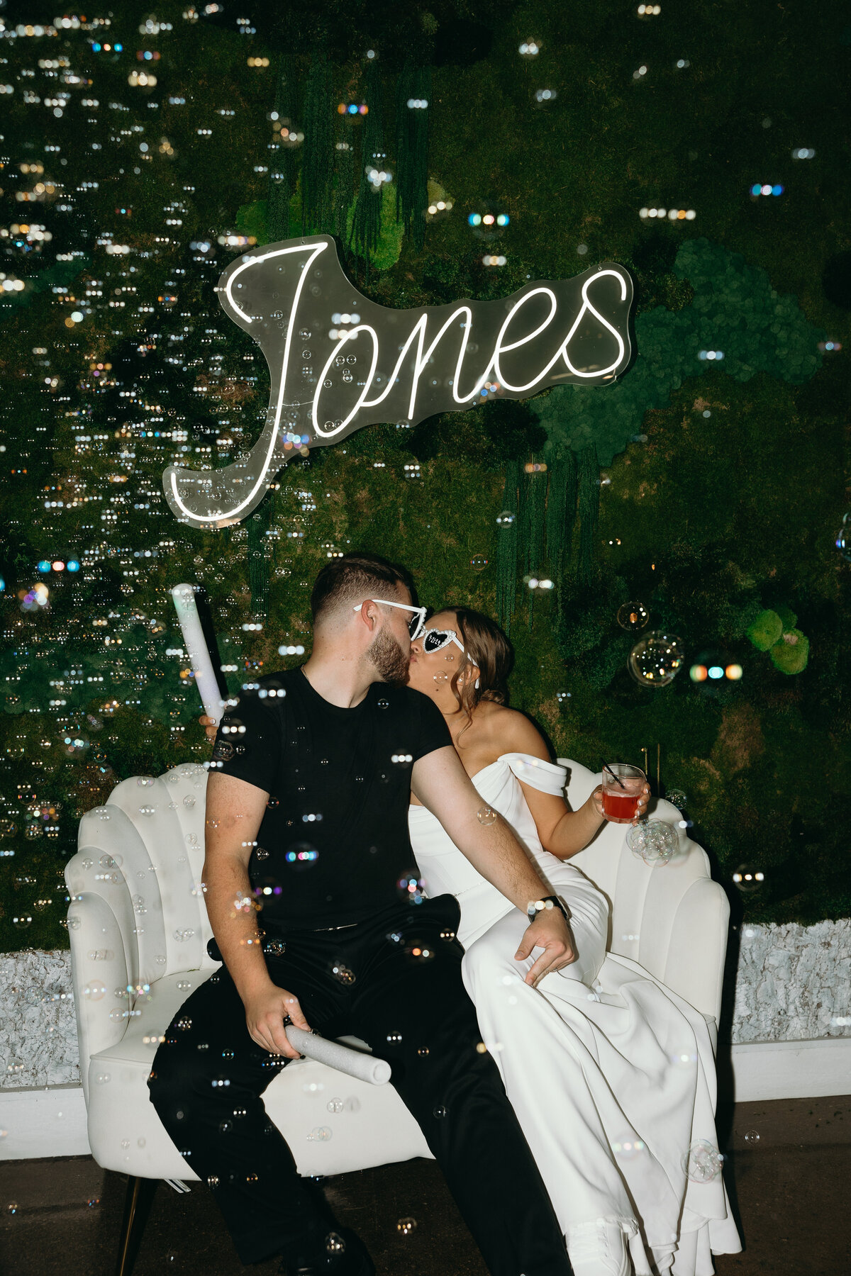 Bride and groom enjoying a romantic moment under a lighted sign, captured by Ryann B Photography in Indianapolis.
