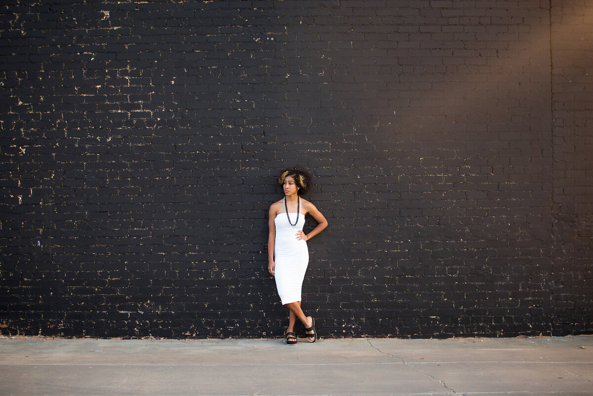 African american girl wearing white dress standing against  a black wall in Tulia Tx
