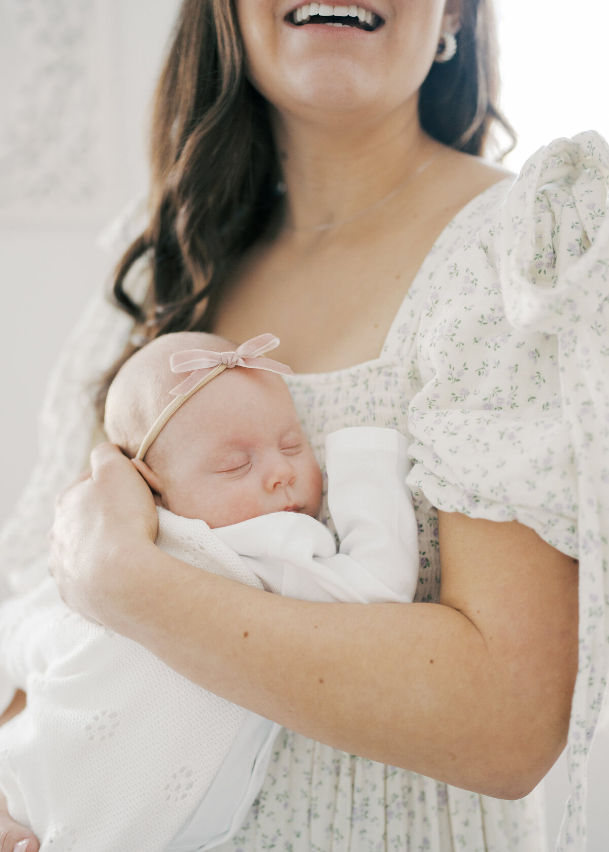 Women holding baby in arms while baby is sleeping in Virginia Beach newborn session 