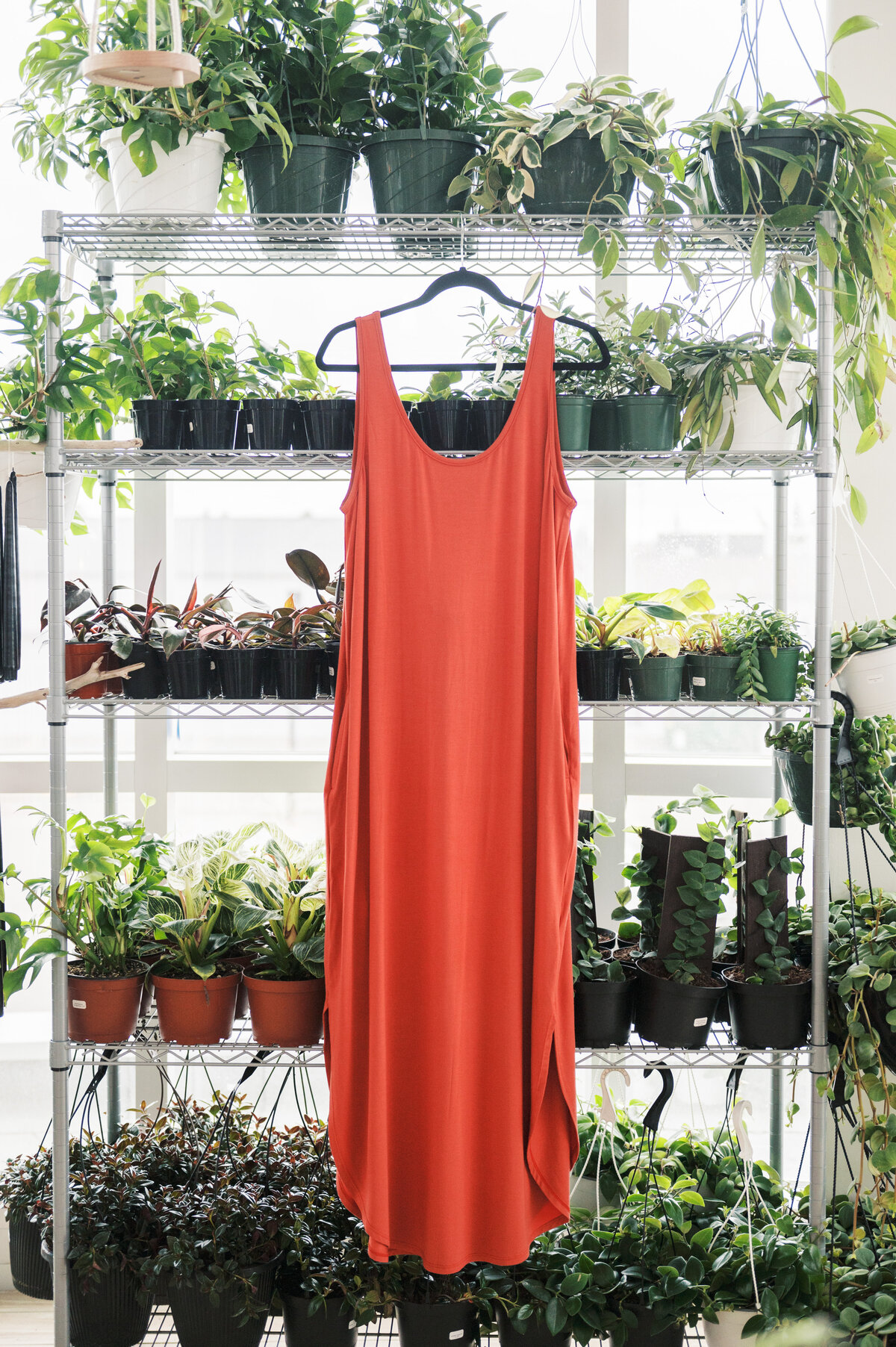 Red sundress on hanger surrounded by plants