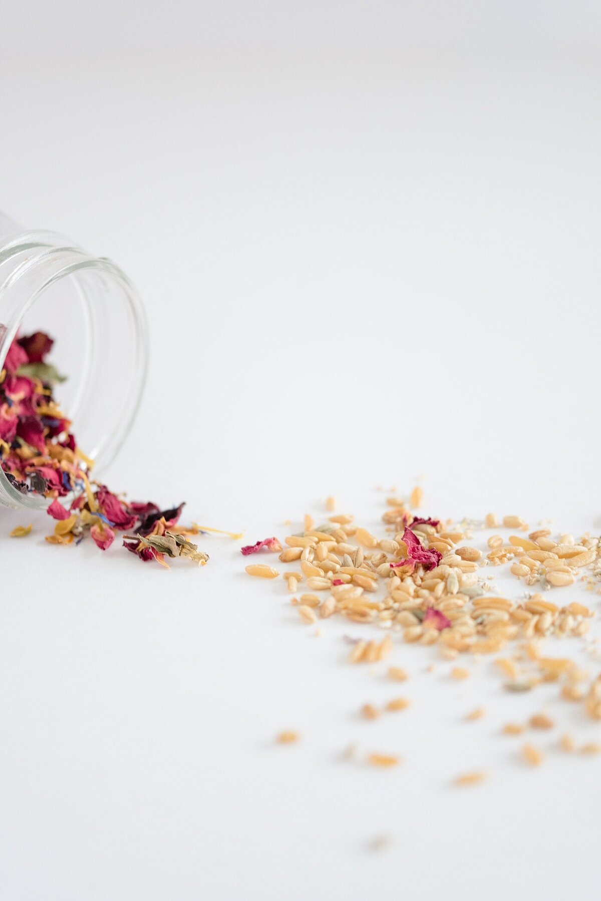 product photography with dried flowers and herbs spread on a table from a glass jar captured by brand photographer
